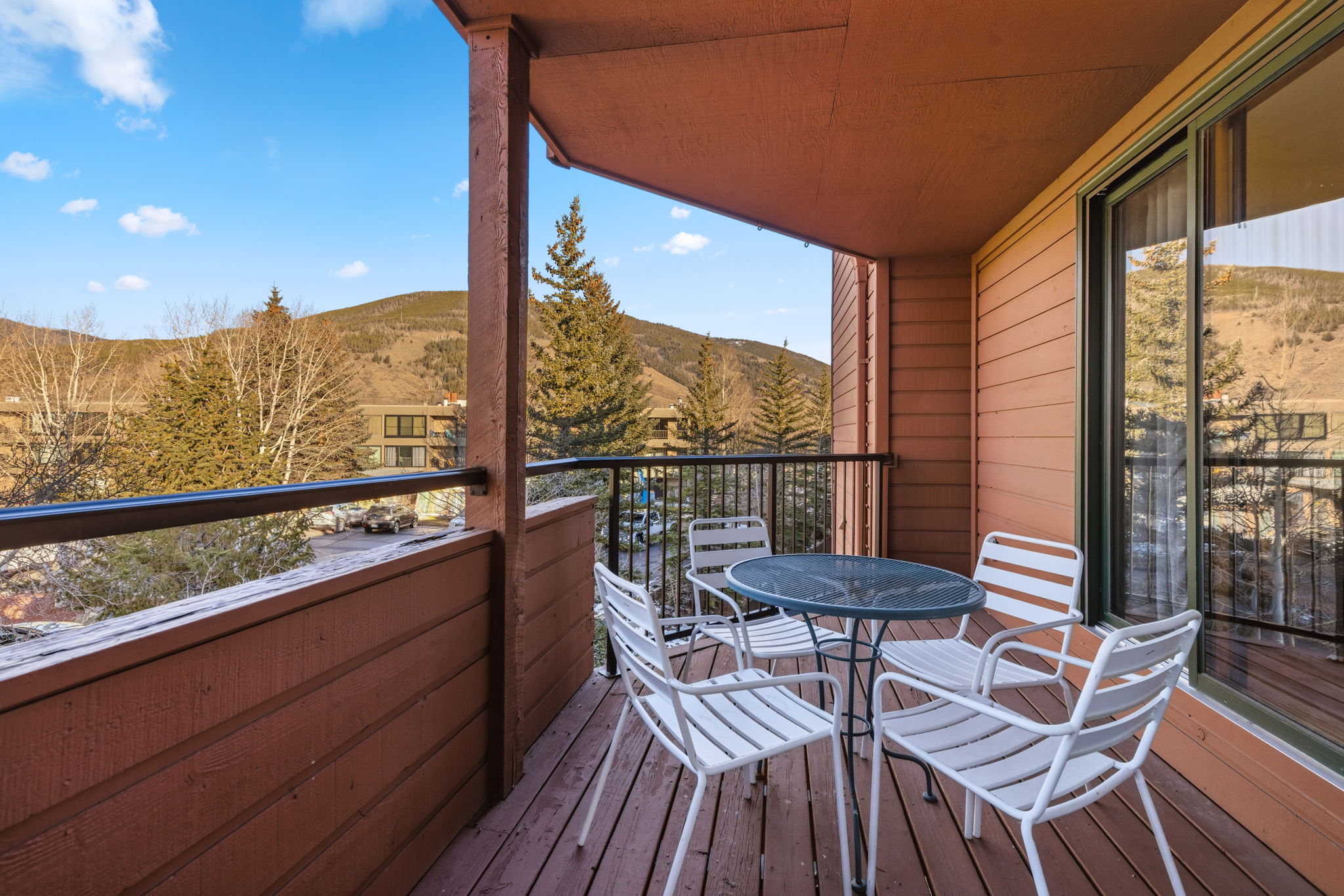 Covered private balcony with seating and mountain views